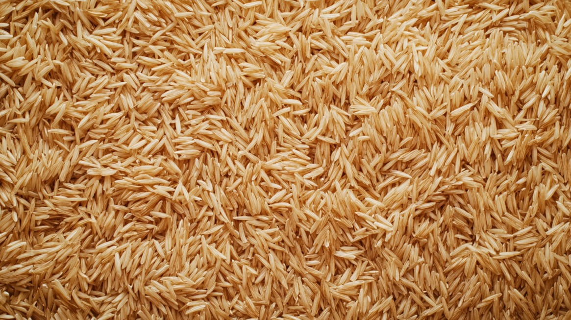 Close-up of uncooked brown rice grains, showcasing their long, fibrous texture and natural tan color